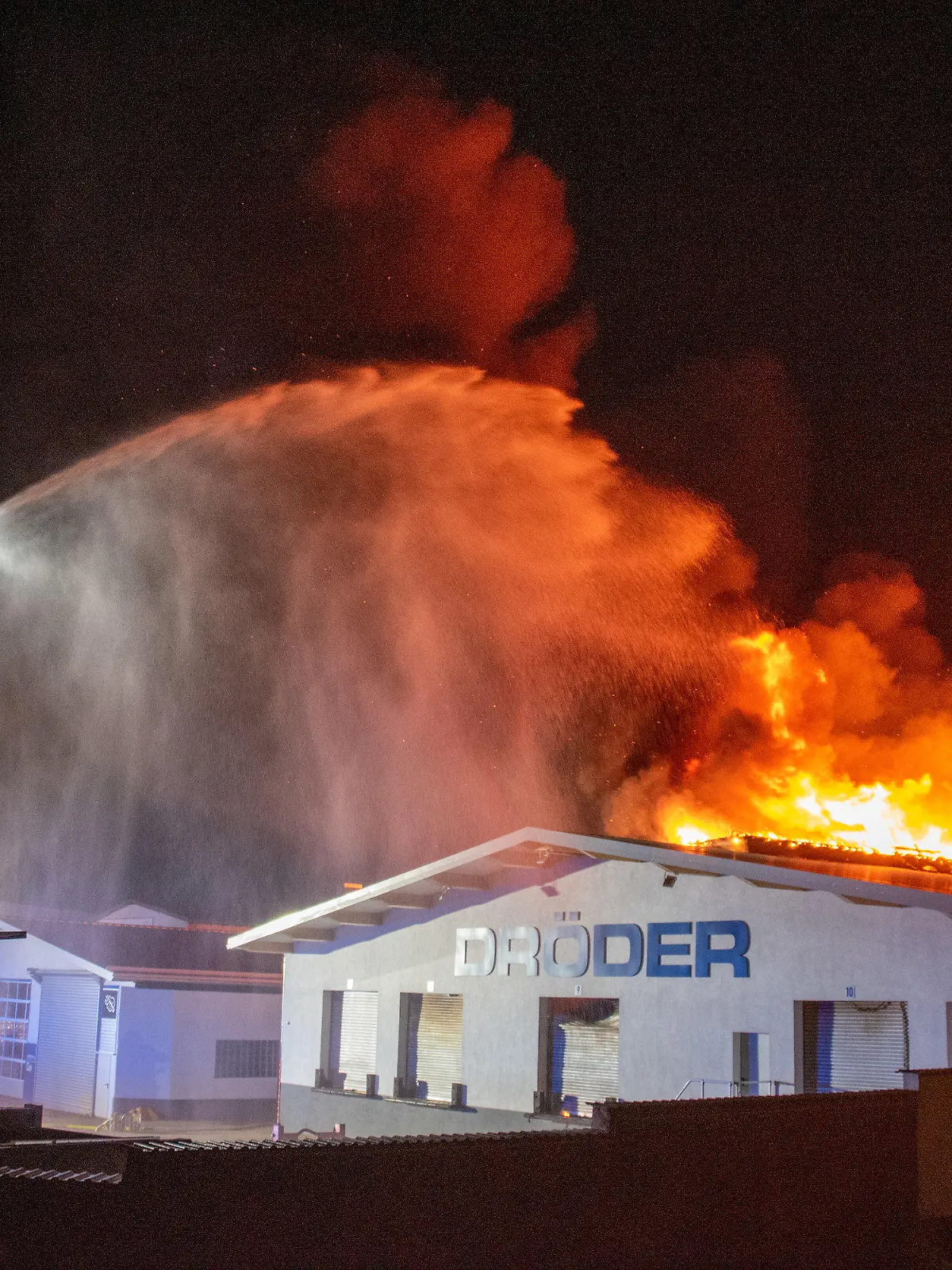 23.05.2021, Hessen, Künzell: Eine Lagerhalle einer Spedition steht in Flammen. Nach dem Brand auf dem Firmengelände in der Nähe von Fulda werden nach Polizeiangaben zwei Menschen vermisst. Diese hätten sich bei Ausbruch des Feuers in der Lagerhalle aufgehalten, sagte ein Polizeisprecher. Foto: Stefan Weber/ Fuldamedia /dpa +++ dpa-Bildfunk +++