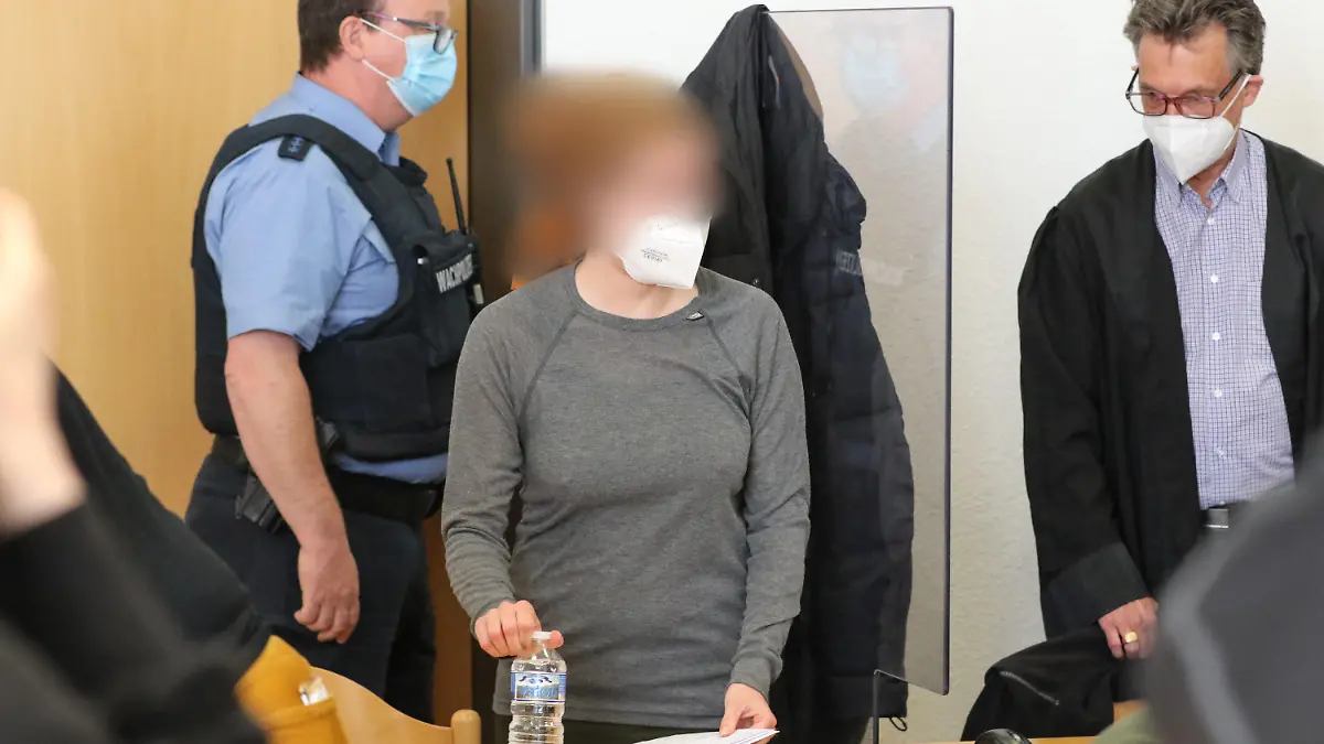 25.05.2021, Hessen, Alsfeld: Die Angeklagte steht in einem Gerichtssaal im Landgericht neben ihrem Verteidiger Tronje Döhmer (r). Rund ein halbes Jahr nach den Protesten gegen den Weiterbau der Autobahn 49 im Dannenröder Forst in Mittelhessen hat am Dienstag der Prozess gegen die Frau begonnen. Sie soll in einem Protest-Camp einen Polizisten gegen den Kopf getreten haben und einem weiteren Beamten ihr Knie ins Gesicht gestoßen haben. (Zu dpa «Proteste zu Prozessbeginn gegen Aktivistin aus dem Dannenröder Forst») Foto: Nadine Weigel/dpa /dpa - ACHTUNG: Die Angeklagte wurde aus rechtlichen Gründen gepixelt +++ dpa-Bildfunk +++