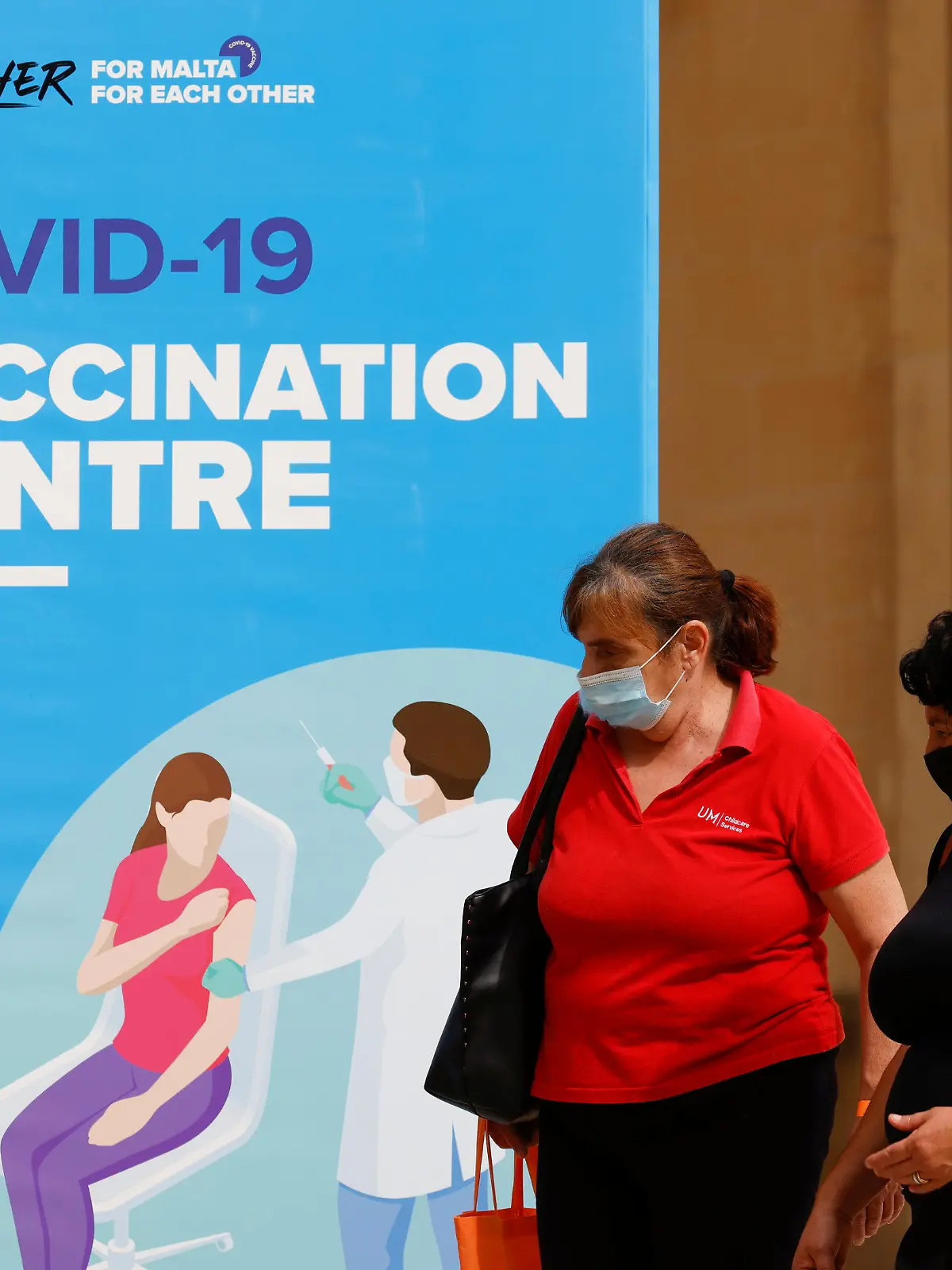 People walk outside a vaccination centre at the University of Malta, after authorities announced that Malta had achieved herd immunity with 70% of the population being receiving at least one vaccine dose against the coronavirus disease (COVID-19), in Msida, Malta May 24, 2021.  REUTERS/Darrin Zammit Lupi