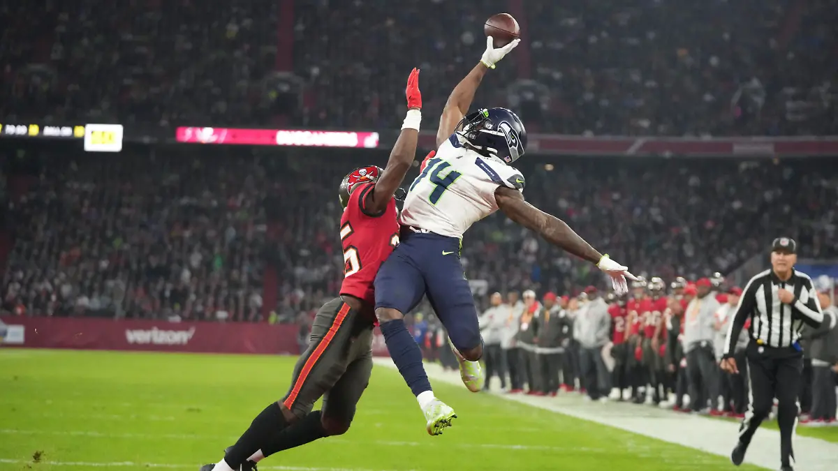 FILE - Seattle Seahawks' DK Metcalf (14) is defended by Tampa Bay Buccaneers' Jamel Dean (35) during the second half of an NFL football game, on Nov. 13, 2022, in Munich, Germany. The NFL's inaugural regular season game in Germany created an economic impact of 70.2 million euros ($77.6 million) for host city Munich, the league said Wednesday May 3, 2023. (AP Photo/Matthias Schrader, File)
