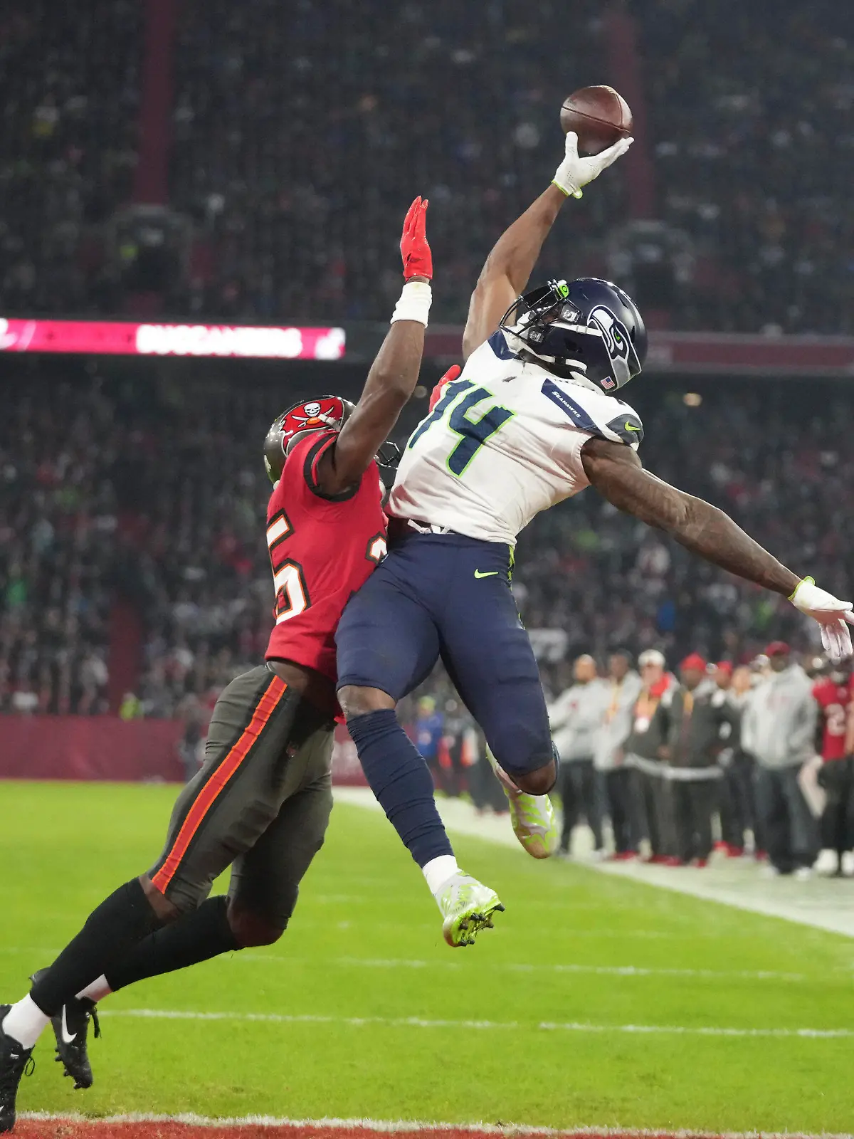 FILE - Seattle Seahawks' DK Metcalf (14) is defended by Tampa Bay Buccaneers' Jamel Dean (35) during the second half of an NFL football game, on Nov. 13, 2022, in Munich, Germany. The NFL's inaugural regular season game in Germany created an economic impact of 70.2 million euros ($77.6 million) for host city Munich, the league said Wednesday May 3, 2023. (AP Photo/Matthias Schrader, File)
