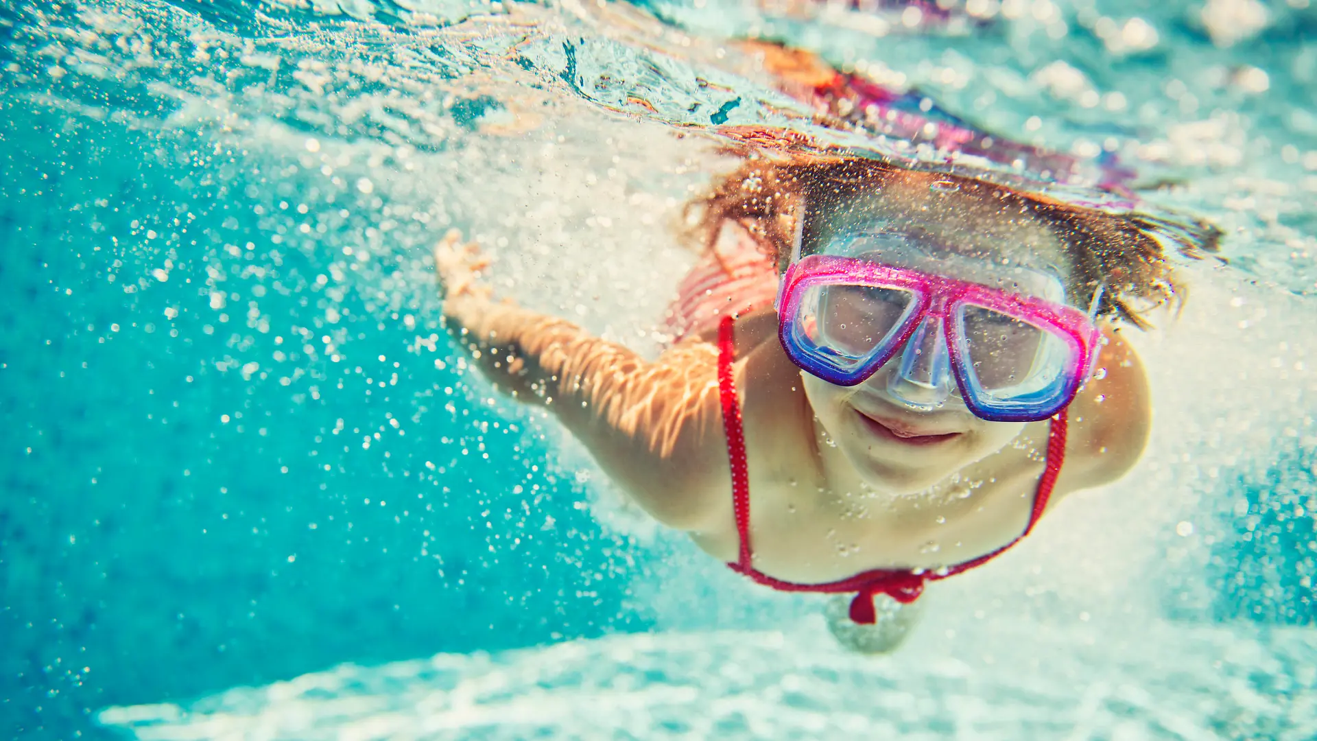 Little girl having fun in swimming pool. Slightly soft focus.