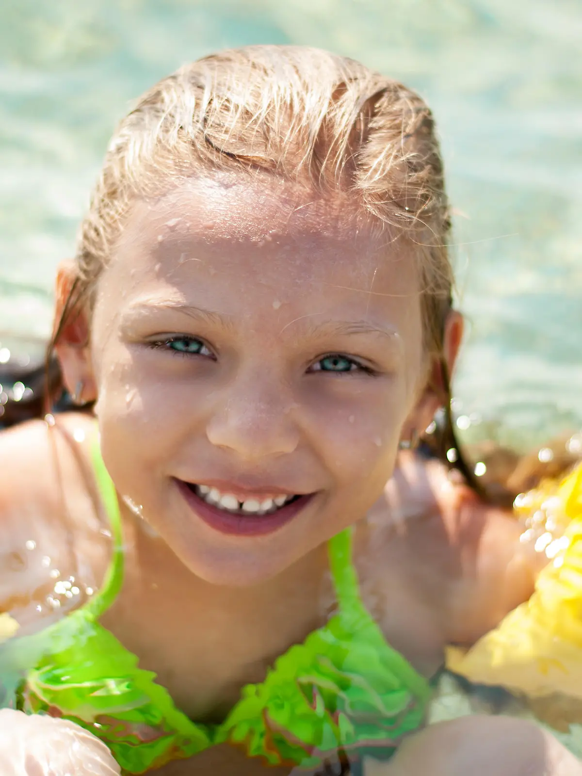 Cute little girl swimming with armbands in the sea.