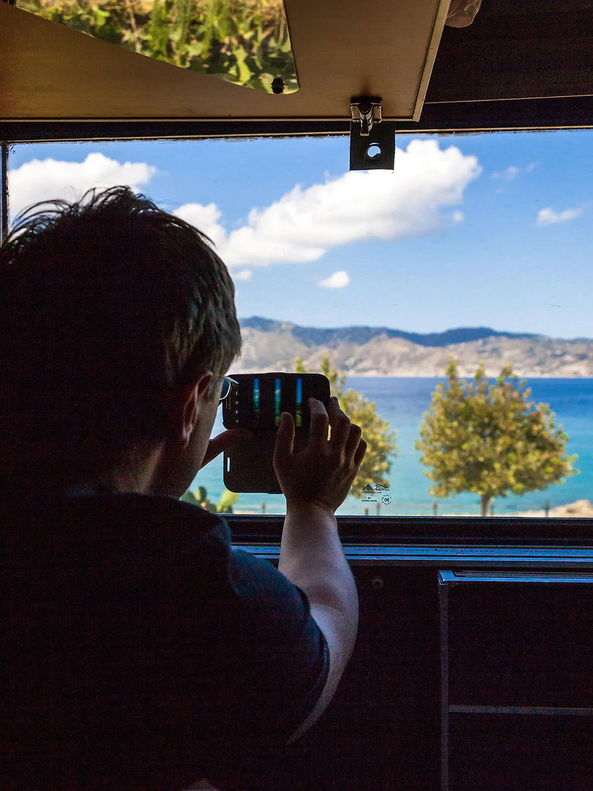 Aussicht aus dem Nachtzug zwischen Mailand und Palermo. Das Mittelmeer ist aus dem Fenster heraus zu sehen. Ein Fahrgast macht ein Foto mit seinem Smartphone. || Mindestpreis 0 Euro 