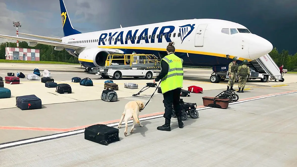 In this photo provided by ONLINER.BY, security use a sniffer dog to check the luggage of passengers on the Ryanair plane with registration number SP-RSM, carrying opposition figure Raman Pratasevich which was traveling from Athens to Vilnius and was diverted to Minsk after a bomb threat, in Minsk International airport, Sunday, May 23, 2021, in BelarusWestern leaders decried the diversion of a plane to Belarus in order to arrest an opposition journalist as an act of piracy and terrorism. The European Union and others on Monday demanded an investigation into the dramatic forced landing of the Ryanair jet. (ONLINER.BY via AP)
