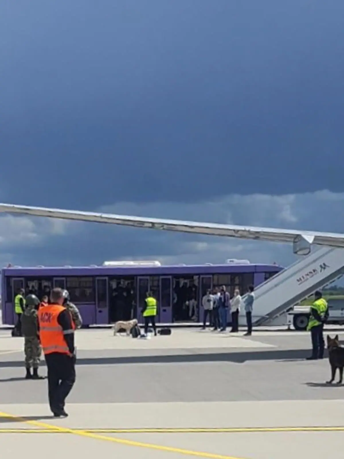 Airport personnel and security forces are seen on the tarmac in front of a Ryanair flight which was forced to land in Minsk, Belarus, May 23, 2021. Picture taken May 23, 2021. Handout via REUTERS ATTENTION EDITORS - THIS PICTURE WAS PROVIDED BY A THIRD PARTY.