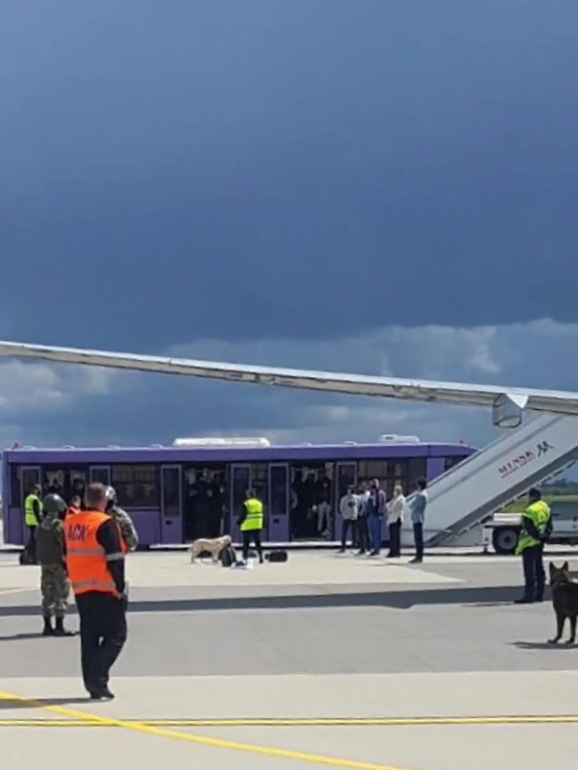 Airport personnel and security forces are seen on the tarmac in front of a Ryanair flight which was forced to land in Minsk, Belarus, May 23, 2021. Picture taken May 23, 2021. Handout via REUTERS ATTENTION EDITORS - THIS PICTURE WAS PROVIDED BY A THIRD PARTY.
