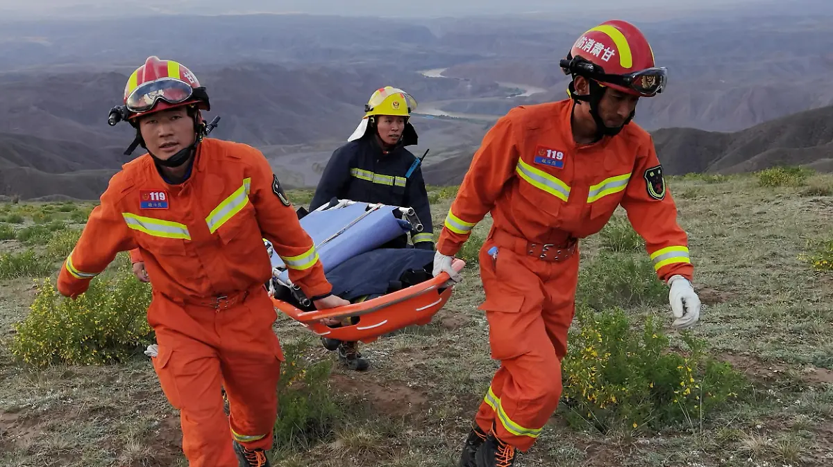 Rescue workers carry a stretcher as they work at the site where extreme cold weather killed participants of an 100-km ultramarathon race in Baiyin, Gansu province, China May 22, 2021. Picture taken May 22, 2021. cnsphoto via REUTERS ATTENTION EDITORS - THIS IMAGE WAS PROVIDED BY A THIRD PARTY. CHINA OUT.