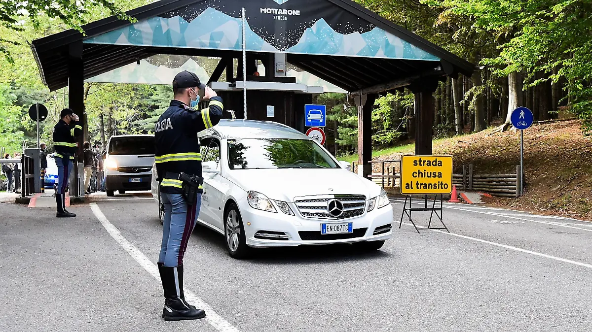 Police officers stand and salute as a hearse carrying one of the victims of a cable car crash drives past, in Stresa, Italy, May 23, 2021. REUTERS/Flavio Lo Scalzo