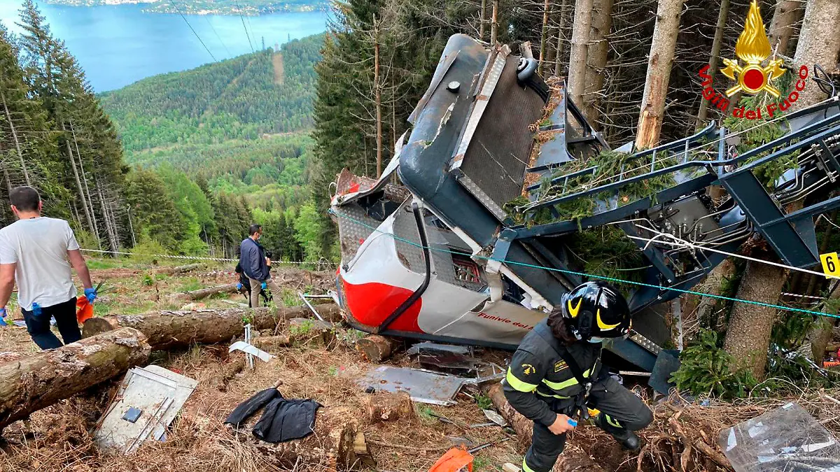 Rescuers work by the wreckage of a cable car after it collapsed near the summit of the Stresa-Mottarone line in the Piedmont region, northern Italy, Sunday, May 23, 2021. A cable car taking visitors to a mountaintop view of some of northern Italy's most picturesque lakes plummeted to the ground Sunday and then tumbled down the slope, killing at least 13 people and sending two children to the hospital, authorities said. (Italian Vigili del Fuoco Firefighters via AP)