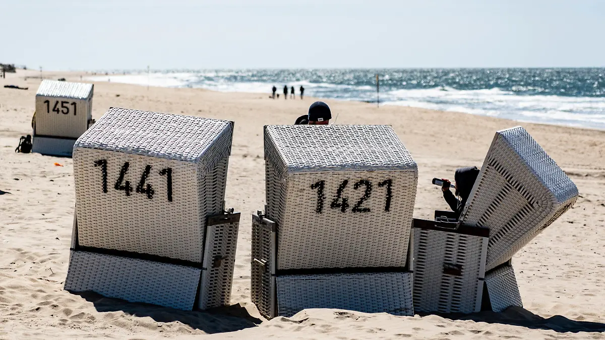 ARCHIV - 24.04.2021, Schleswig-Holstein, Westerland auf Sylt: Ein Mann sitzt am Strand von Sylt in einem Strandkorb. Der Kreis Norfriesland startet nach monatelanger Corona-Unterbrechung am 1. Mai unter strengen Auflagen wieder mit dem Tourismus (zu dpa: "Nordfriesland startet als touristische Modellregion") Foto: Axel Heimken/dpa +++ dpa-Bildfunk +++