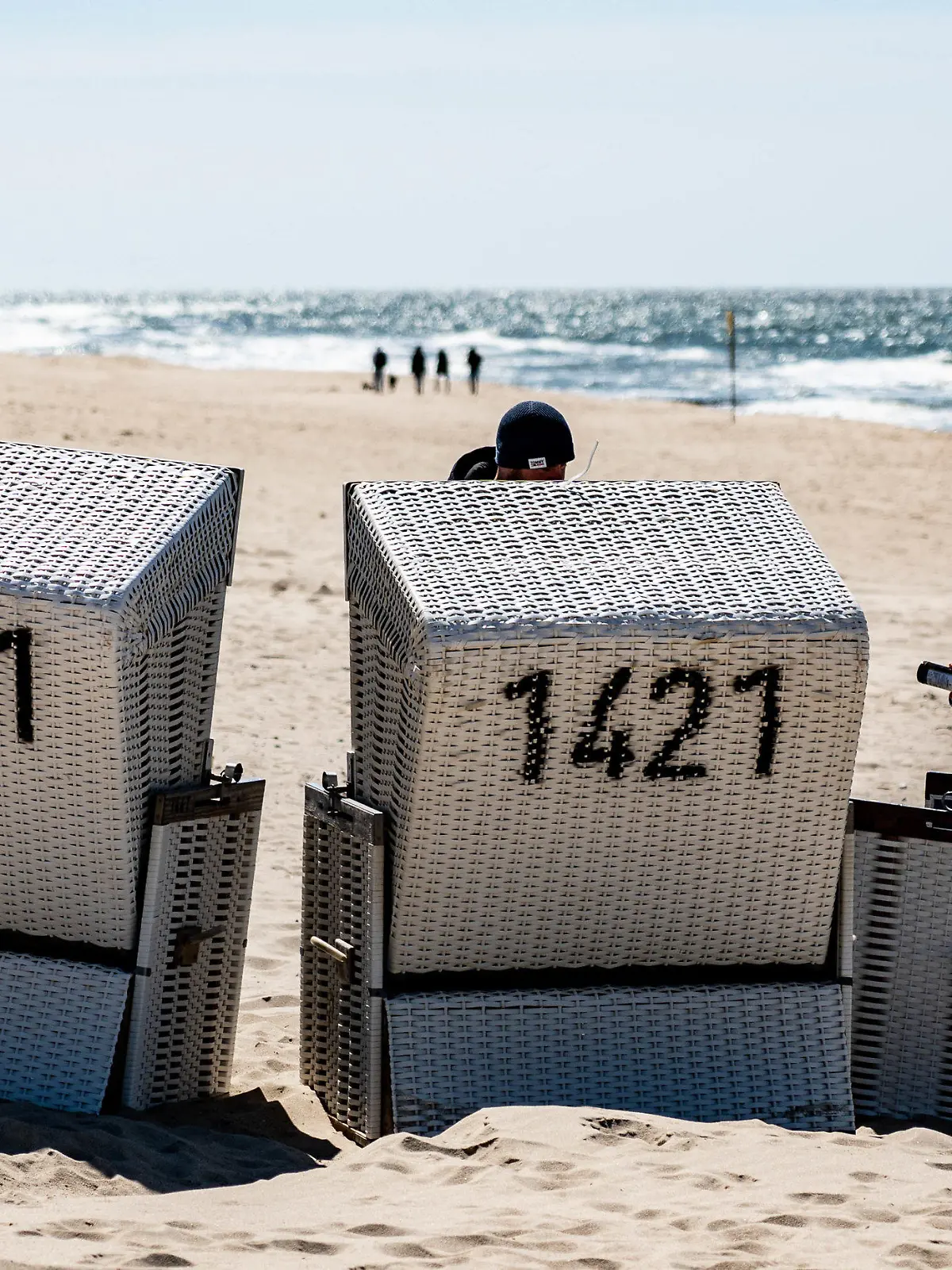 ARCHIV - 24.04.2021, Schleswig-Holstein, Westerland auf Sylt: Ein Mann sitzt am Strand von Sylt in einem Strandkorb. Der Kreis Norfriesland startet nach monatelanger Corona-Unterbrechung am 1. Mai unter strengen Auflagen wieder mit dem Tourismus (zu dpa: "Nordfriesland startet als touristische Modellregion") Foto: Axel Heimken/dpa +++ dpa-Bildfunk +++