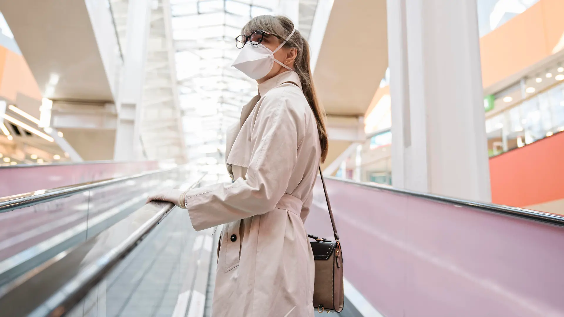  Woman with face mask and disposable gloves on an escalator in a shopping center model released Symbolfoto AHSF02593