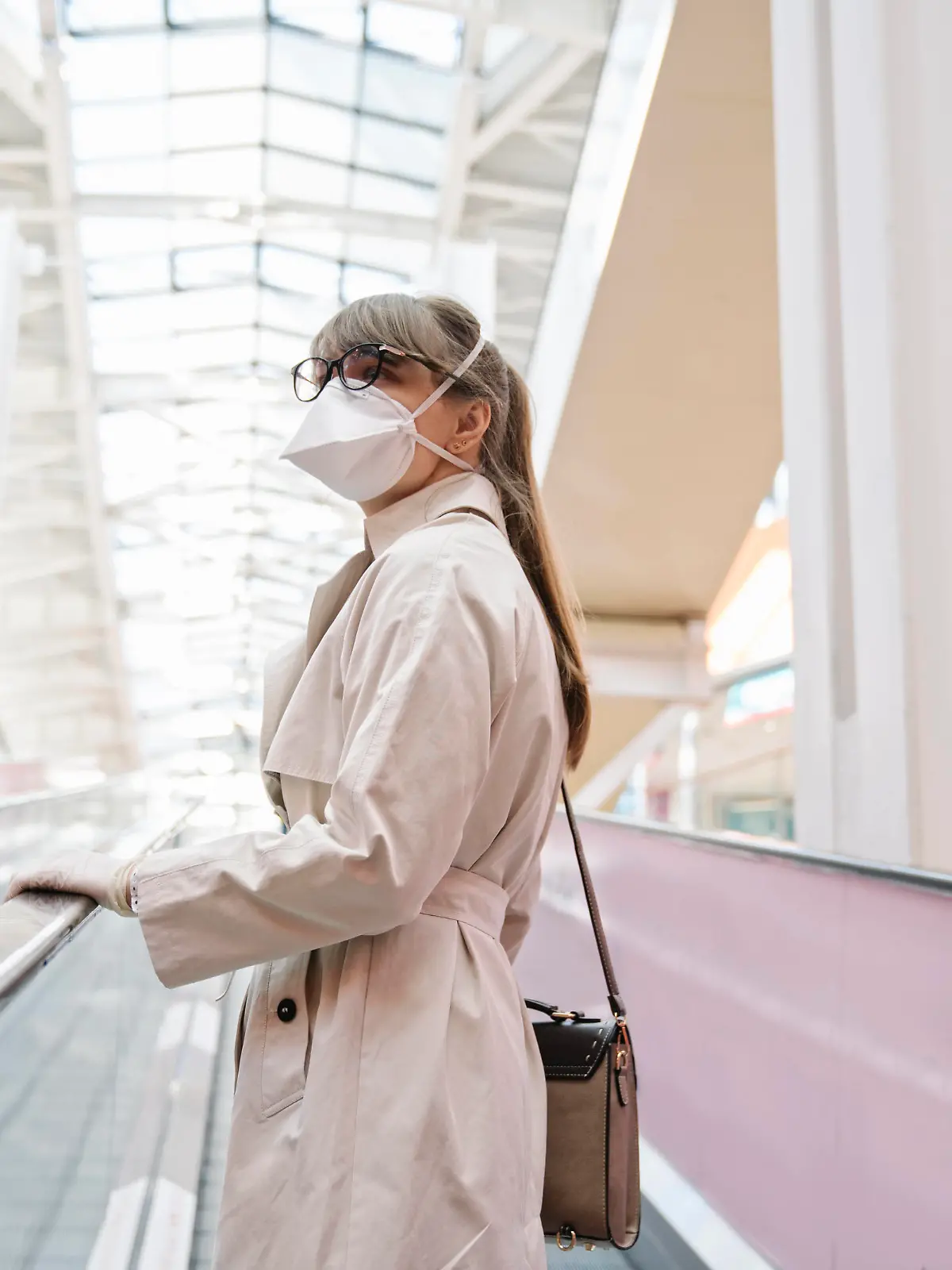  Woman with face mask and disposable gloves on an escalator in a shopping center model released Symbolfoto AHSF02593