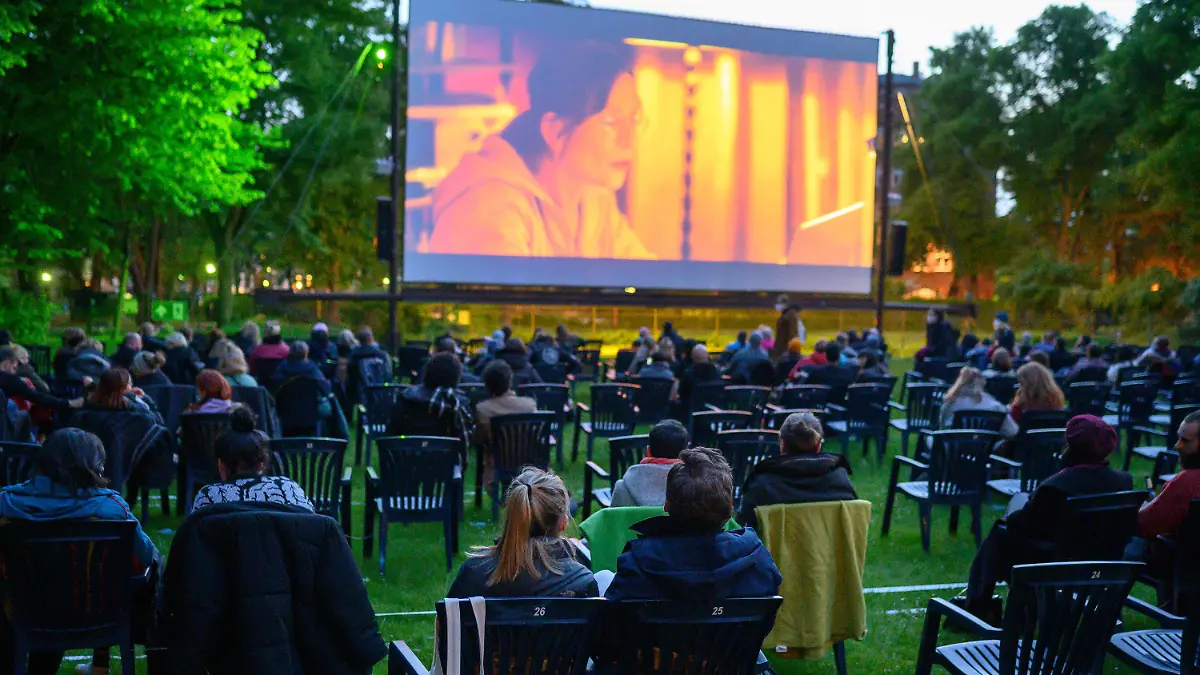 20.05.2021, Berlin: Besucher sitzen im Freiluftkino Kreuzberg, um sich den Film "Futur drei" anzuschauen. Kinos in Berlin dürfen ab heute wieder Veranstaltungen unter freiem Himmel mit maximal 250 Personen anbieten. Das Freiluftkino Kreuzberg bietet als erstes Freiluftkino in Berlin nach einer coronabedingten Pause eine Filmvorführung an. Foto: Bernd von Jutrczenka/dpa - ACHTUNG: Nur zur redaktionellen Verwendung im Zusammenhang mit der aktuellen Berichterstattung +++ dpa-Bildfunk +++