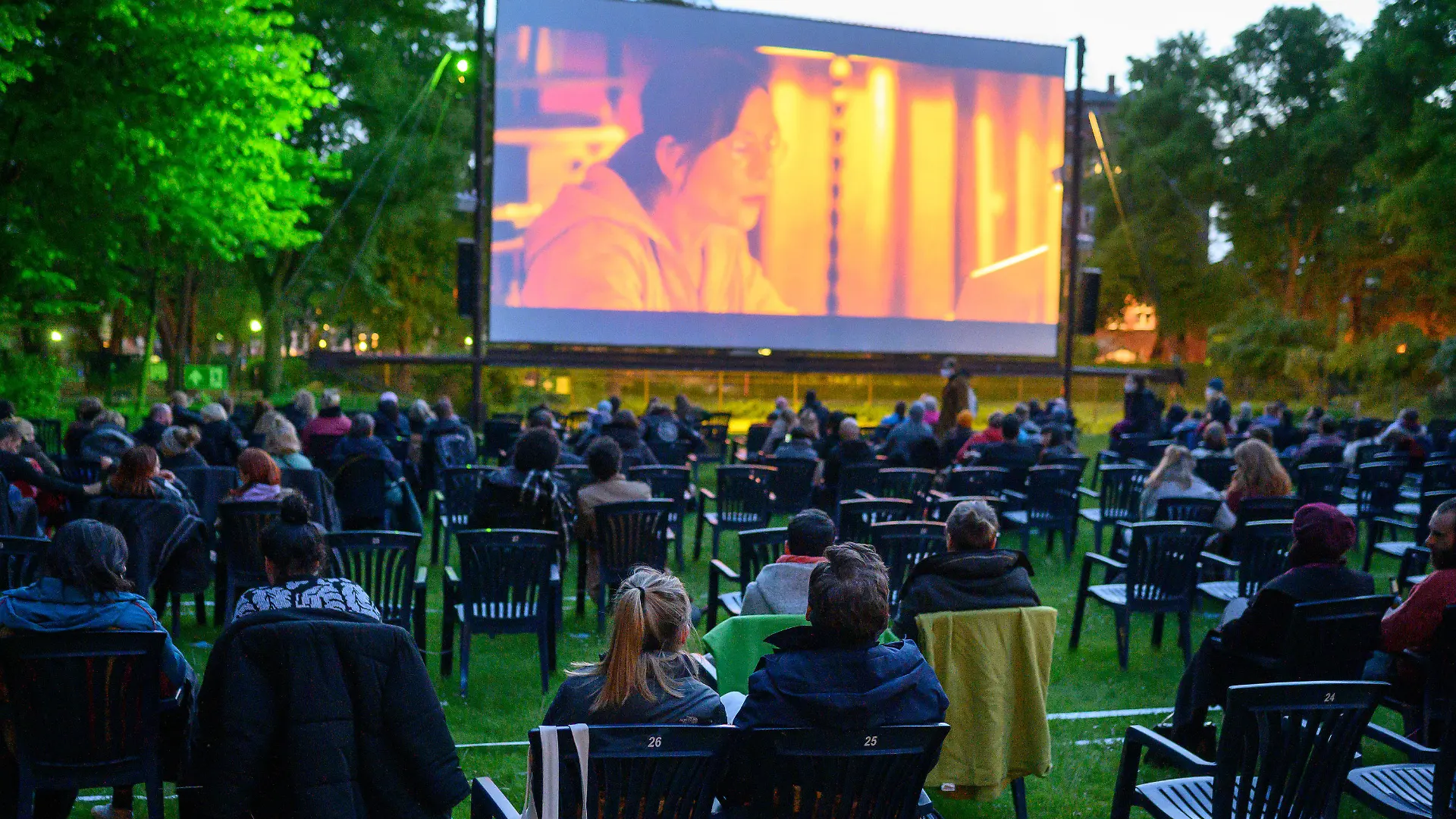 20.05.2021, Berlin: Besucher sitzen im Freiluftkino Kreuzberg, um sich den Film "Futur drei" anzuschauen. Kinos in Berlin dürfen ab heute wieder Veranstaltungen unter freiem Himmel mit maximal 250 Personen anbieten. Das Freiluftkino Kreuzberg bietet als erstes Freiluftkino in Berlin nach einer coronabedingten Pause eine Filmvorführung an. Foto: Bernd von Jutrczenka/dpa - ACHTUNG: Nur zur redaktionellen Verwendung im Zusammenhang mit der aktuellen Berichterstattung +++ dpa-Bildfunk +++
