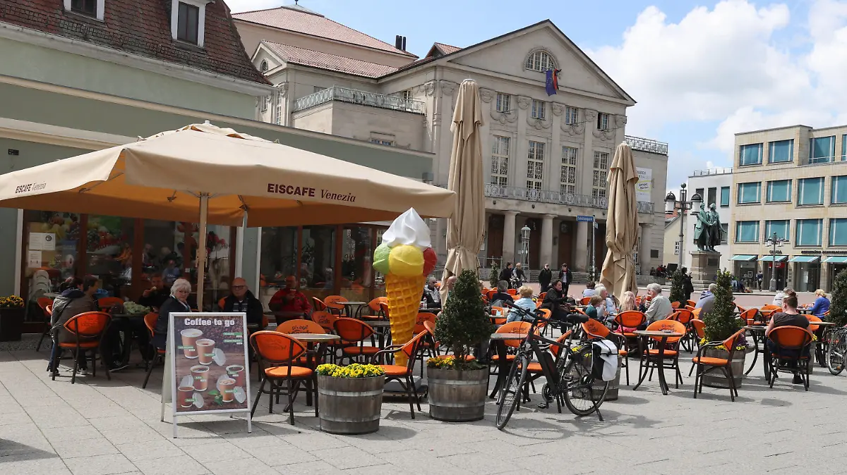 20.05.2021, Thüringen, Weimar: Gäste sitzen vor einem Cafe im Zentrum der Stadt. Seit heute dürfen in Weimar Gaststätten und Cafes wieder die Außengastronomie öffnen. Foto: Bodo Schackow/dpa-Zentralbild/dpa +++ dpa-Bildfunk +++