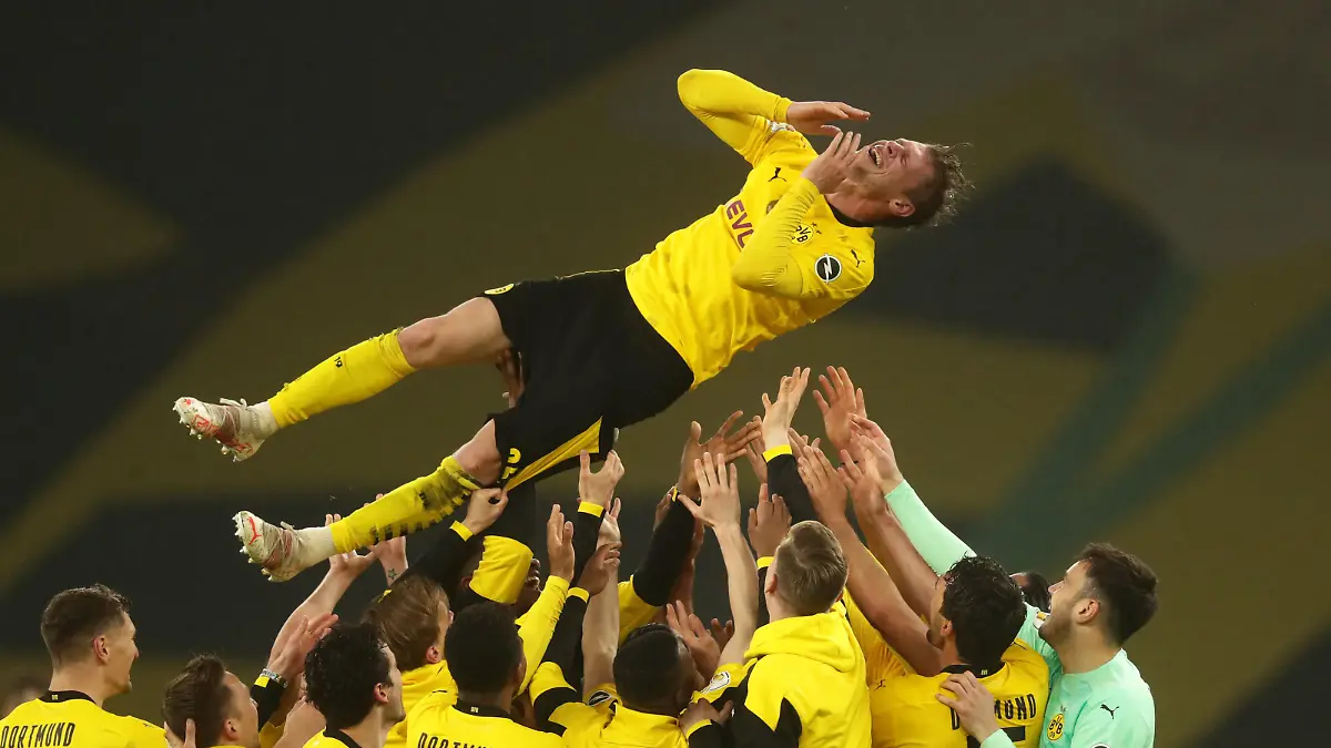 BERLIN, GERMANY - MAY 13: Teammates throw Lukas Piszczek of Borussia Dortmund of Borussia Dortmund up in the air after winning the DFB Cup final match between RB Leipzig and Borussia Dortmund at Olympic Stadium on May 13, 2021 in Berlin, Germany. Sporting stadiums around Germany remain under strict restrictions due to the Coronavirus Pandemic as Government social distancing laws prohibit fans inside venues resulting in games being played behind closed doors. (Photo by Filip Singer - Pool/Getty Images)
