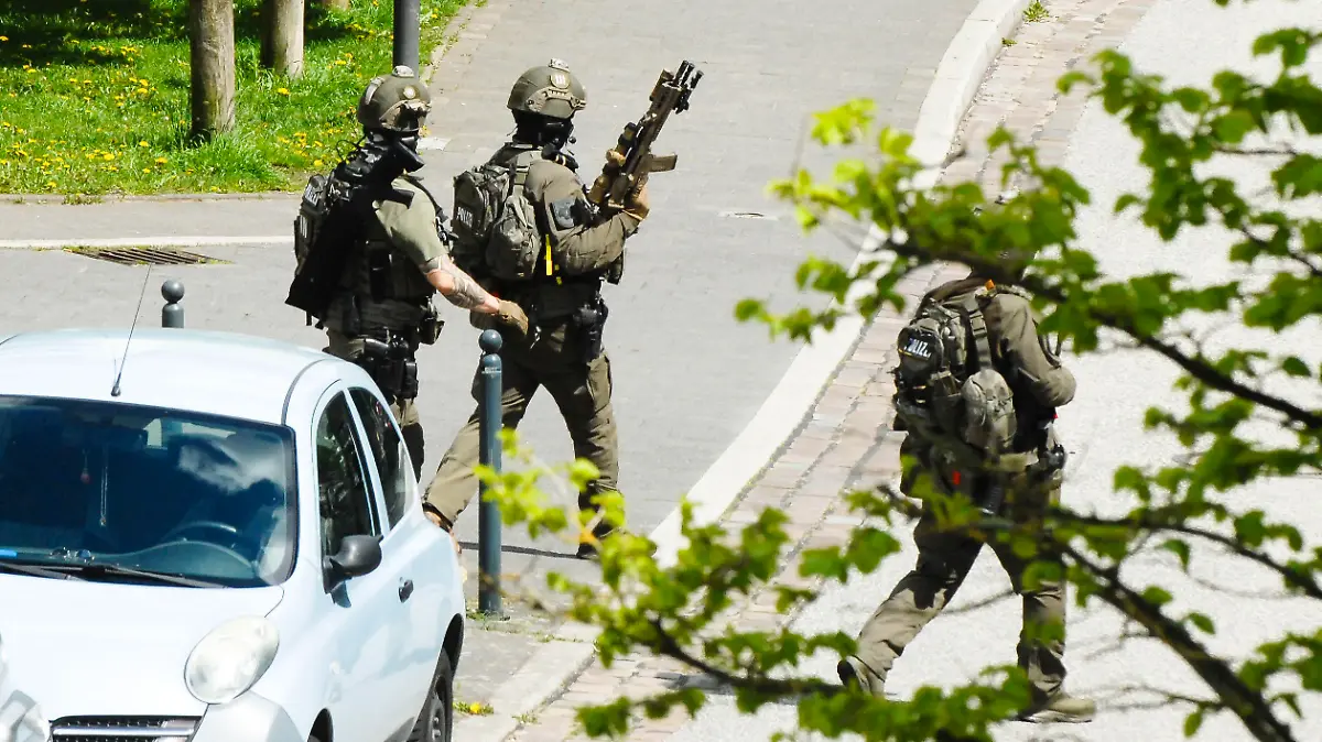 01.01.2006, Schleswig-Holstein, Kiel: Drei Polizisten des SEK gehen mit Gewehren über eine Straße am Einsatzort. Nach den Schüssen in Dänischenhagen (Kreis Rendsburg-Eckernförde) hatte die Polizei auch das Brauereiviertel in Kiel abgeriegelt. Foto: Wulf Pfeiffer/dpa +++ dpa-Bildfunk +++