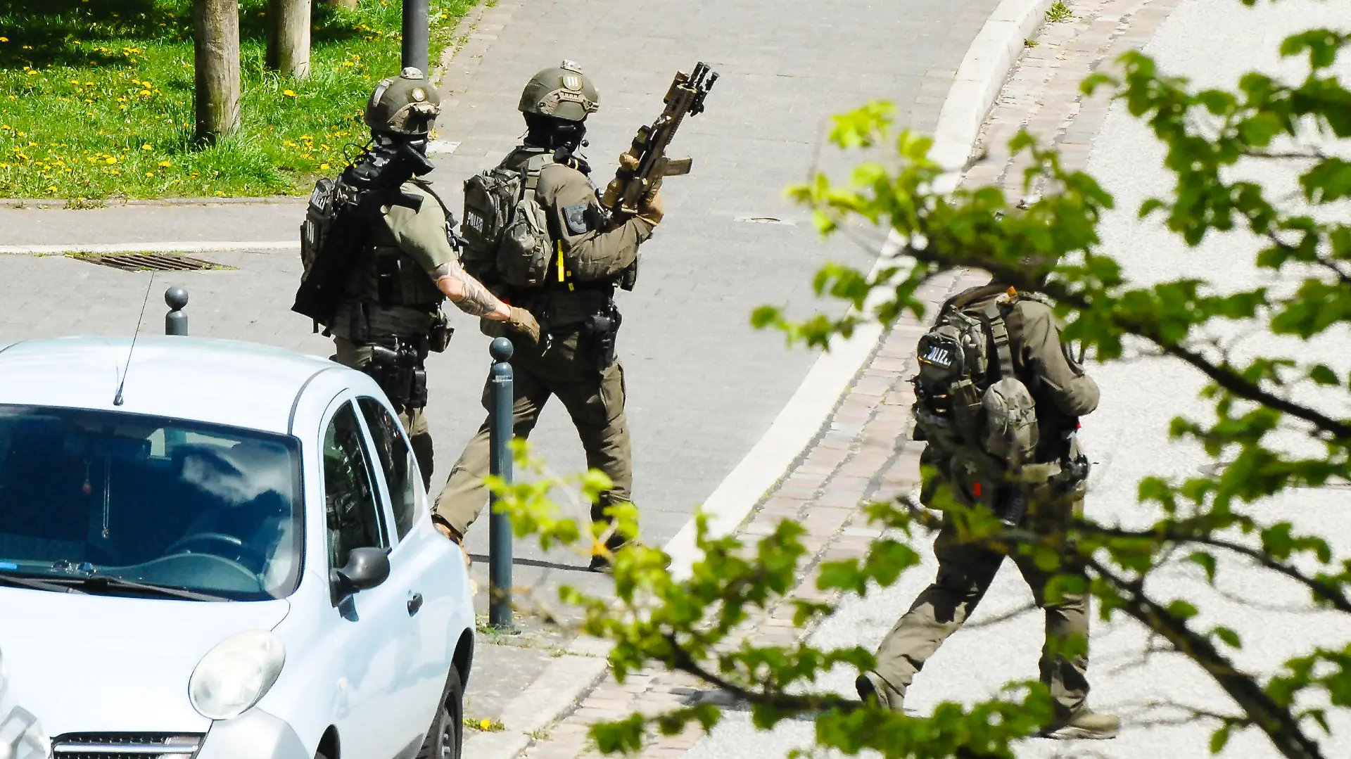 01.01.2006, Schleswig-Holstein, Kiel: Drei Polizisten des SEK gehen mit Gewehren über eine Straße am Einsatzort. Nach den Schüssen in Dänischenhagen (Kreis Rendsburg-Eckernförde) hatte die Polizei auch das Brauereiviertel in Kiel abgeriegelt. Foto: Wulf Pfeiffer/dpa +++ dpa-Bildfunk +++