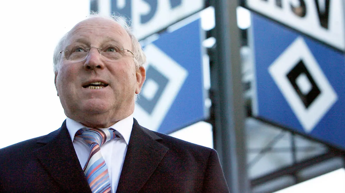 ARCHIV - Hamburgs früherer Fußballspieler Uwe Seeler posiert am 25.10.2006 in Hamburg neben dem HSV-Logo. Fußball-Idol Uwe Seeler fürchtet mehr denn je um die Bundesliga-Existenz seines Hamburger SV. «Wenn man so in den Abstiegskampf geht, dann wird das nichts. Wenn wir so weitermachen, habe ich keine Hoffnung mehr. Nicht mal ein Fünkchen. Das ist einfach jämmerlich», sagte der einstige Torjäger und spätere Präsident des HSV der «Bild»-Zeitung (Donnerstag) nach der 0:4-Niederlage des Tabellen-14. bei 1899 Hoffenheim. Foto: Maurizo Gambarini dpa/lno (zu dpa-Korr.: «HSV «eine Katastrophe» - Uwe Seeler ohne Hoffnung» vom 12.04.2012 )  +++(c) dpa - Bildfunk+++
