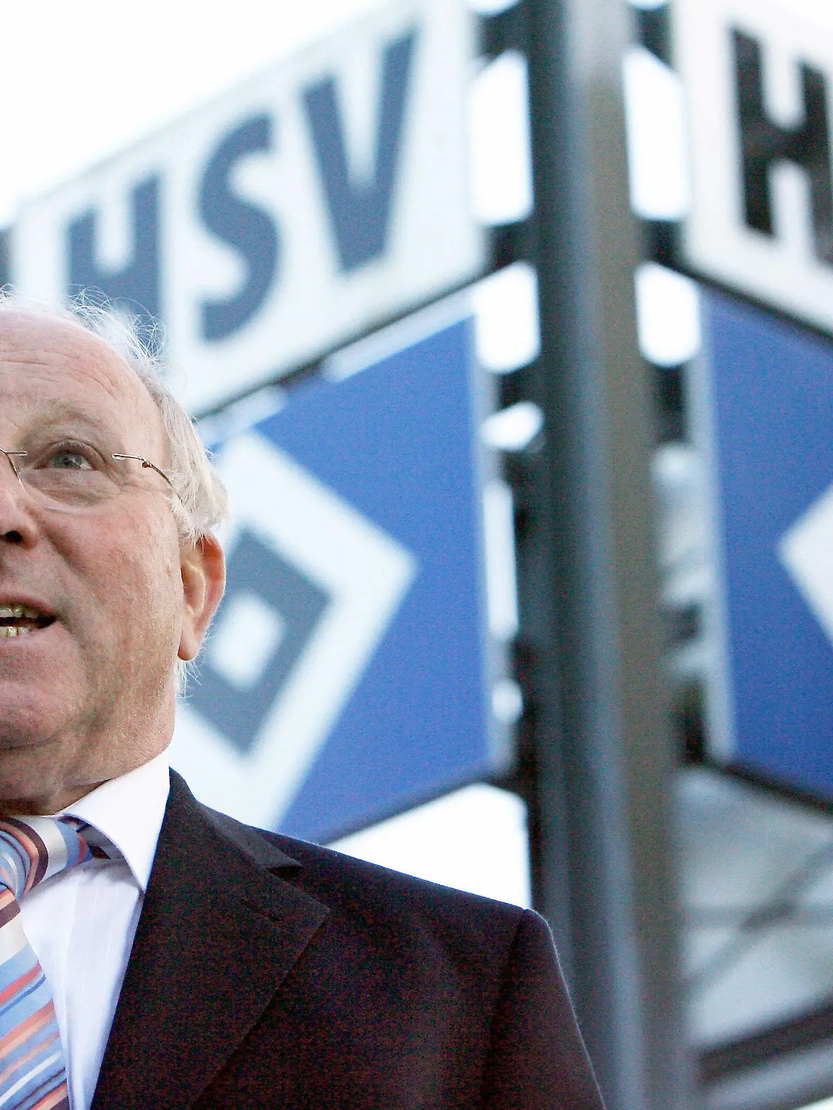 ARCHIV - Hamburgs früherer Fußballspieler Uwe Seeler posiert am 25.10.2006 in Hamburg neben dem HSV-Logo. Fußball-Idol Uwe Seeler fürchtet mehr denn je um die Bundesliga-Existenz seines Hamburger SV. «Wenn man so in den Abstiegskampf geht, dann wird das nichts. Wenn wir so weitermachen, habe ich keine Hoffnung mehr. Nicht mal ein Fünkchen. Das ist einfach jämmerlich», sagte der einstige Torjäger und spätere Präsident des HSV der «Bild»-Zeitung (Donnerstag) nach der 0:4-Niederlage des Tabellen-14. bei 1899 Hoffenheim. Foto: Maurizo Gambarini dpa/lno (zu dpa-Korr.: «HSV «eine Katastrophe» - Uwe Seeler ohne Hoffnung» vom 12.04.2012 )  +++(c) dpa - Bildfunk+++