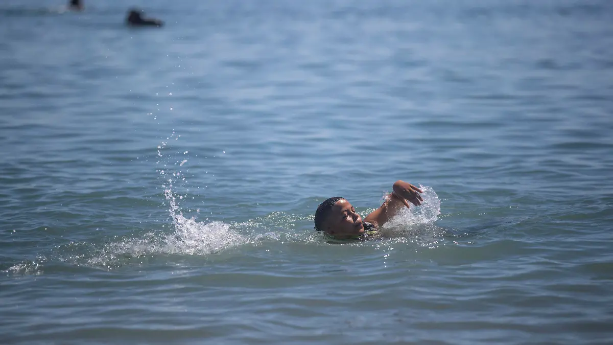A boy attempts to swim from the Moroccan border town of Fnideq towards the Spanish enclave of Ceuta, on Wednesday, May 19, 2021.  Spain’s north African enclave of Ceuta has awakened to a humanitarian crisis after thousands of migrants who crossed over from Morocco spent the night sleeping where they could find shelter. (AP Photo/Mosa'ab Elshamy)
