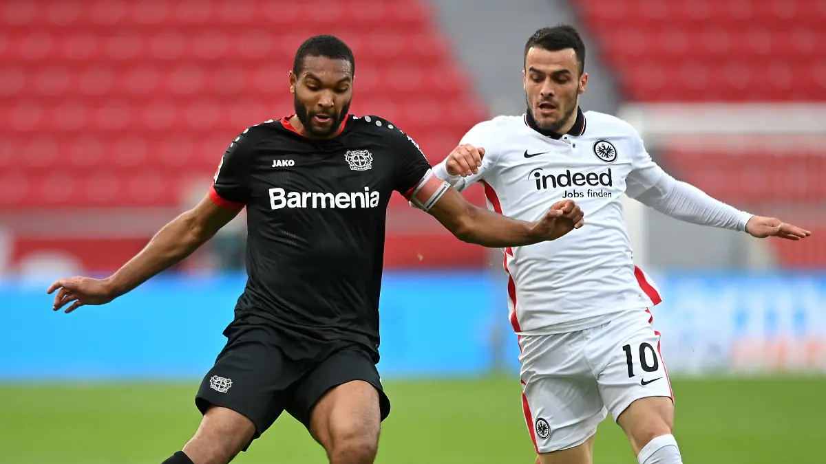 LEVERKUSEN, GERMANY - APRIL 24: Jonathan Tah of Bayer 04 Leverkusen battles for possession with Filip Kostic of Eintracht Frankfurt  during the Bundesliga match between Bayer 04 Leverkusen and Eintracht Frankfurt at BayArena on April 24, 2021 in Leverkusen, Germany. Sporting stadiums around Germany remain under strict restrictions due to the Coronavirus Pandemic as Government social distancing laws prohibit fans inside venues resulting in games being played behind closed doors. (Photo by Sascha Steinbach - Pool/Getty Images)