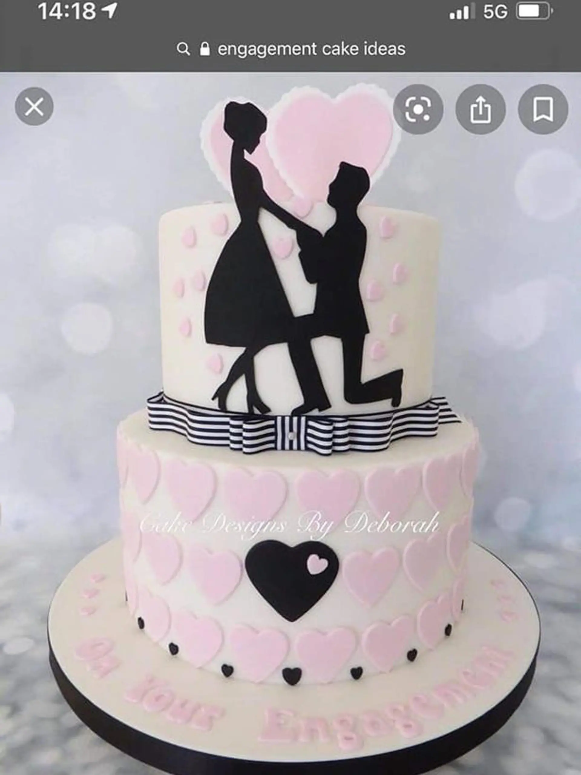 Eine mehrstöckige Torte in weiß, mit einem Miniatur-Brautpaar oben auf dem Kuchen, die für besondere Anlässe wie Verlobungen oder Hochzeiten angeboten wird.