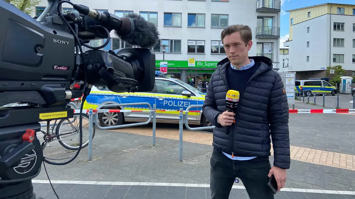 RTL-Reporter Bastian Vollmer steht vor dem Brauereiviertel in der Kieler Innenstadt und berichtet live.