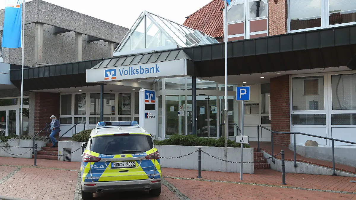 18.05.2021, Nordrhein-Westfalen, Spenge: Ein Polizeiwagen steht vor der örtlichen Volksbank. Einbrecher haben einen unterirdischen Tunnel bis zu einer Volksbank in Spenge (Kreis Herford) gegraben. Bauarbeiter seien darauf gestoßen, nachdem sie abgesackte Pflastersteine wieder ebnen wollten, sagte eine Polizeisprecherin am Dienstagabend. Foto: Friso Gentsch/dpa +++ dpa-Bildfunk +++