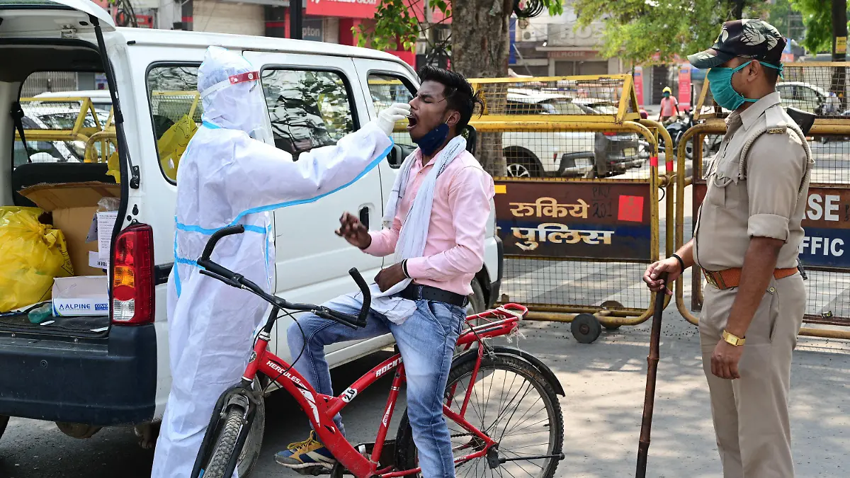 10.05.2021, Indien, Prayagraj: Medizinisches Personal entnimmt einen Abstrich von einem Pendler, um ihn auf das Coronavirus zu testen. Die Zahl der täglichen Corona-Neuinfizierten ist im derzeit besonders von der Pandemie heimgesuchten Indien erstmals seit mehreren Tagen wieder unter die Marke von 400 000 gefallen. Foto: Prabhat Kumar Verma/ZUMA Wire/dpa +++ dpa-Bildfunk +++