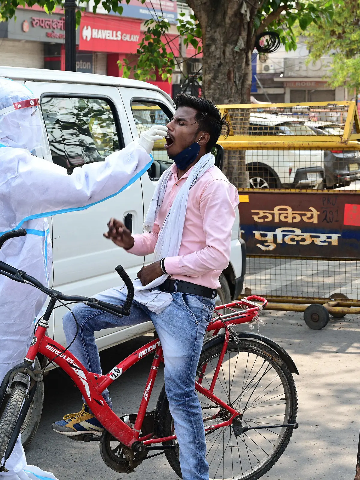 10.05.2021, Indien, Prayagraj: Medizinisches Personal entnimmt einen Abstrich von einem Pendler, um ihn auf das Coronavirus zu testen. Die Zahl der täglichen Corona-Neuinfizierten ist im derzeit besonders von der Pandemie heimgesuchten Indien erstmals seit mehreren Tagen wieder unter die Marke von 400 000 gefallen. Foto: Prabhat Kumar Verma/ZUMA Wire/dpa +++ dpa-Bildfunk +++