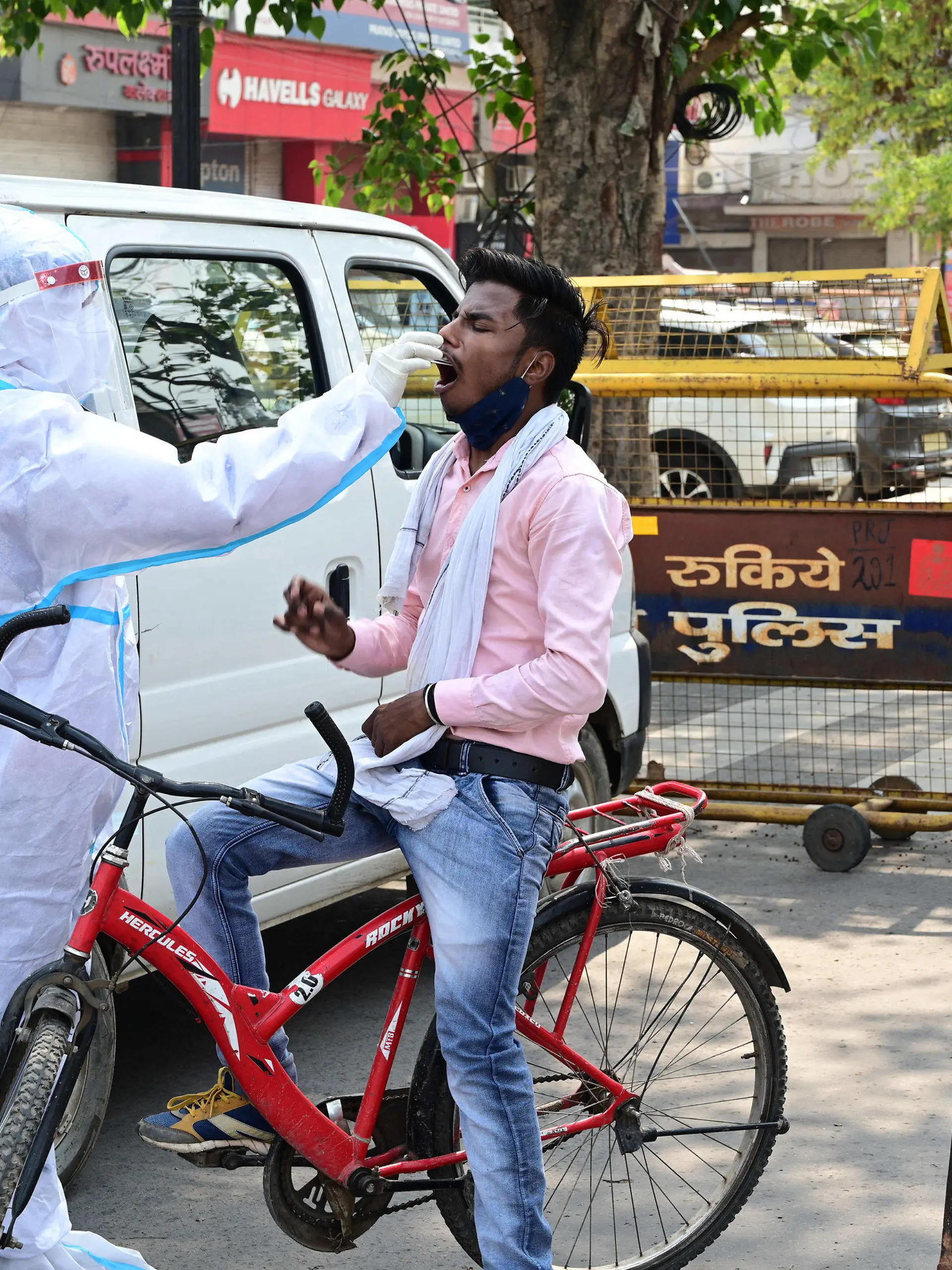 10.05.2021, Indien, Prayagraj: Medizinisches Personal entnimmt einen Abstrich von einem Pendler, um ihn auf das Coronavirus zu testen. Die Zahl der täglichen Corona-Neuinfizierten ist im derzeit besonders von der Pandemie heimgesuchten Indien erstmals seit mehreren Tagen wieder unter die Marke von 400 000 gefallen. Foto: Prabhat Kumar Verma/ZUMA Wire/dpa +++ dpa-Bildfunk +++