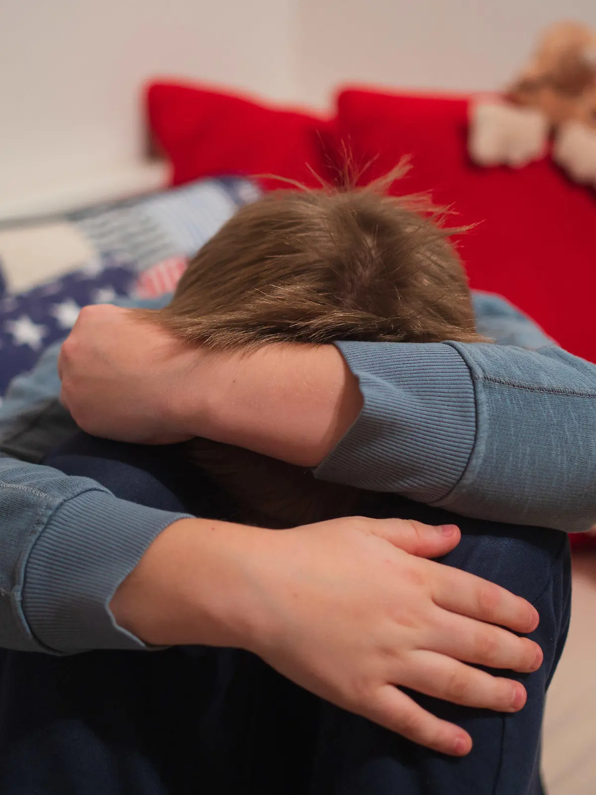 ILLUSTRATION - 16.01.2021, Bayern, Neustadt Bei Coburg: ARCHIV - Ein Junge kauert sich auf seinem Bett zusammen. (Zu dpa: «Barmer: Immer mehr Kinder und Jugendliche mit seelischen Problemen») Foto: Nicolas Armer/dpa +++ dpa-Bildfunk +++