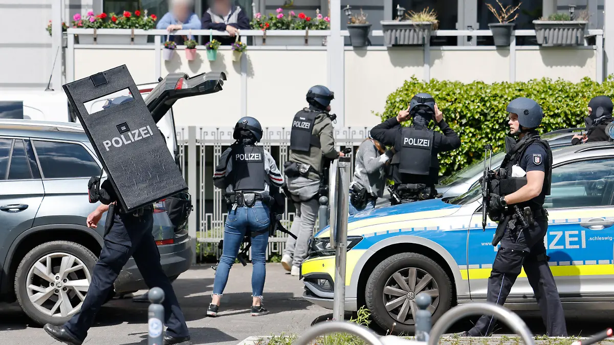 19.05.2021, Schleswig-Holstein, Kiel: Polizisten bereiten sich vor einem Gebäude im Brauereiviertel der Stadt auf ihren Einsatz vor. Nach den Schüssen in Dänischenhagen (Kreis Rendsburg-Eckernförde) hat die Polizei auch das Brauereiviertel in Kiel abgeriegelt. Dort soll ein weißer SUV, der möglicherweise dem Täter zugeordnet werden kann, gesehen worden sein, wie eine Sprecherin des Landespolizeiamtes am Mittwoch sagte. Foto: Frank Molter/dpa - ACHTUNG: Person(en) wurde(n) aus rechtlichen Gründen gepixelt +++ dpa-Bildfunk +++