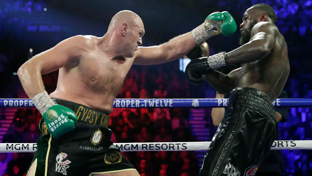 FILE - In this Feb. 22, 2020, file photo, Tyson Fury, left, of England, fights Deontay Wilder during a WBC heavyweight championship boxing match in Las Vegas. Fury is turning his attention to an all-British heavyweight unification bout with Anthony Joshua early next year after ending plans for a third fight with Deontay Wilder. Fury claimed the WBC belt from Wilder with a seventh-round stoppage in their rematch in Las Vegas in February and the British boxer’s U.S. promoter, Bob Arum, was looking to stage a third fight between them in front of 15,000 spectators at the home of NFL team Las Vegas Raiders on Dec. 19. (AP Photo/Isaac Brekken, File)