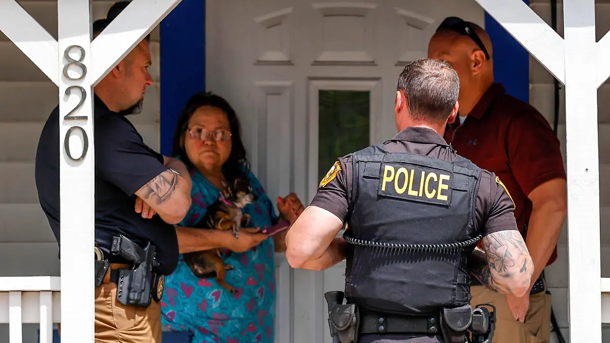 Henryetta Police Chief Steve Norman,left, visits the home of Nathan Brewer in Henryetta Okla., on Wednesday, May 3, 2023. Brittany Brewer was found dead at a home in Henryetta along with six others on Monday. Jesse McFadden, an Oklahoma sex offender who was released from prison early shot his wife, her three children and their two friends in the head and then killed himself, authorities confirmed Wednesday as concerns grew about why he was free in the first place. (Nathan J. Fish/The Oklahoman via AP)