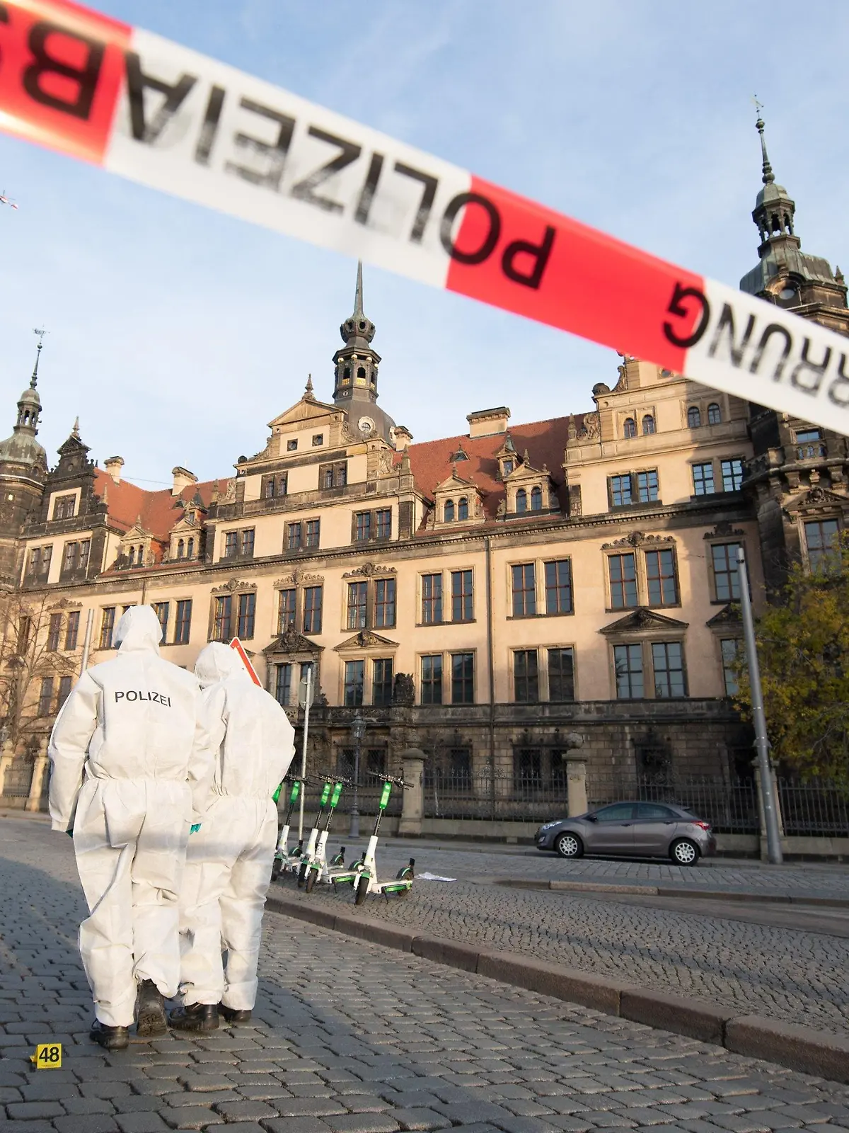 ARCHIV - 25.11.2019, Sachsen, Dresden: Zwei Mitarbeiter der Spurensicherung stehen vor dem Residenzschloss mit dem Grünen Gewölbe hinter einem Absperrband. (zu «Nach Einbruch in Grünes Gewölbe: Museen beraten Sicherheit") Foto: Sebastian Kahnert/zb/dpa +++ dpa-Bildfunk +++