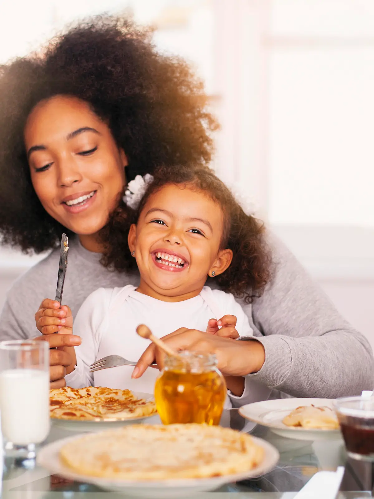 African-American young mother and daughter having breakfast