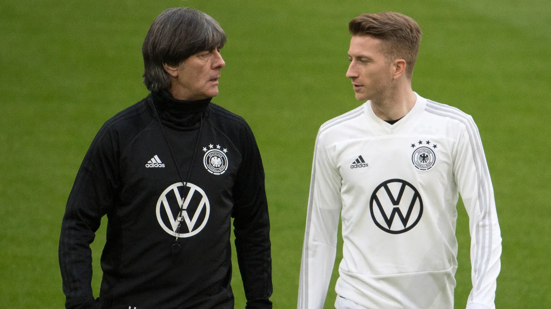 ARCHIV - 23.03.2019, Niederlande, Amsterdam: Trainer Joachim Löw (l) und Spieler Marco Reus unterhalten sich beim Training der deutschen Fußball Nationalmannschaft am Tag vor dem EM-Qualifikationsspiel gegen die Niederlande in der Johan Cruyff Arena.  (zu dpa: «Müller, Hummels, Reus: Corona verschafft Löw drei EM-Bonus-Plätze») Foto: Federico Gambarini/dpa +++ dpa-Bildfunk +++