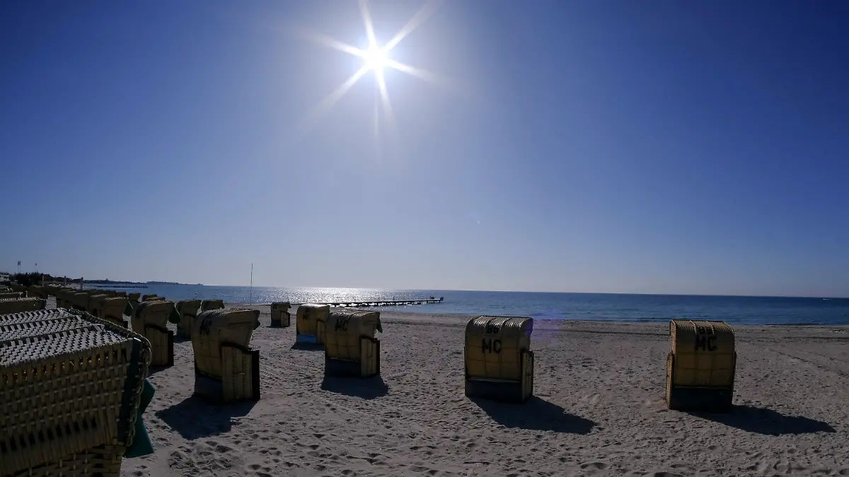20.04.2021, Schleswig-Holstein, Burgtiefe: Die Sonne scheint bei blauem Himmel auf Strandkörbe am Südstrand auf der Insel Fehmarn. Foto: Frank Molter/dpa +++ dpa-Bildfunk +++