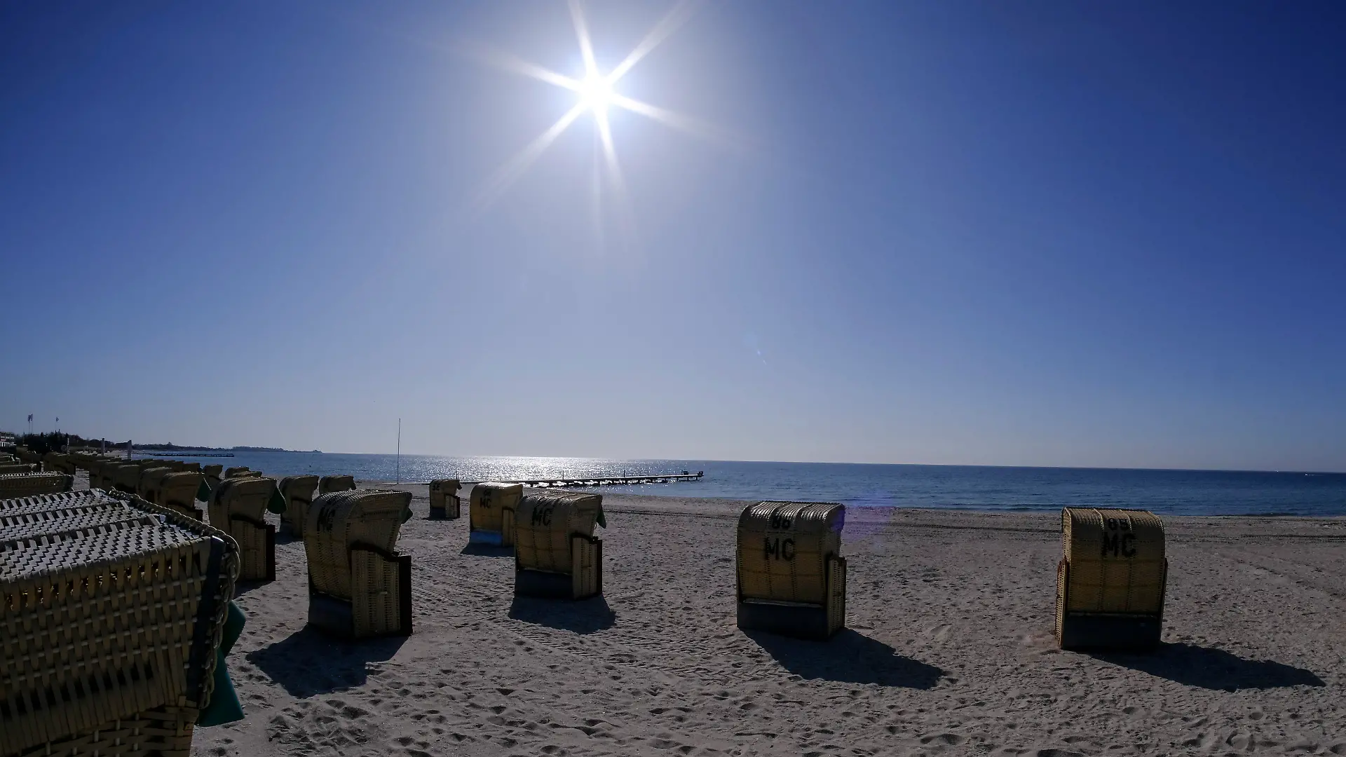 20.04.2021, Schleswig-Holstein, Burgtiefe: Die Sonne scheint bei blauem Himmel auf Strandkörbe am Südstrand auf der Insel Fehmarn. Foto: Frank Molter/dpa +++ dpa-Bildfunk +++
