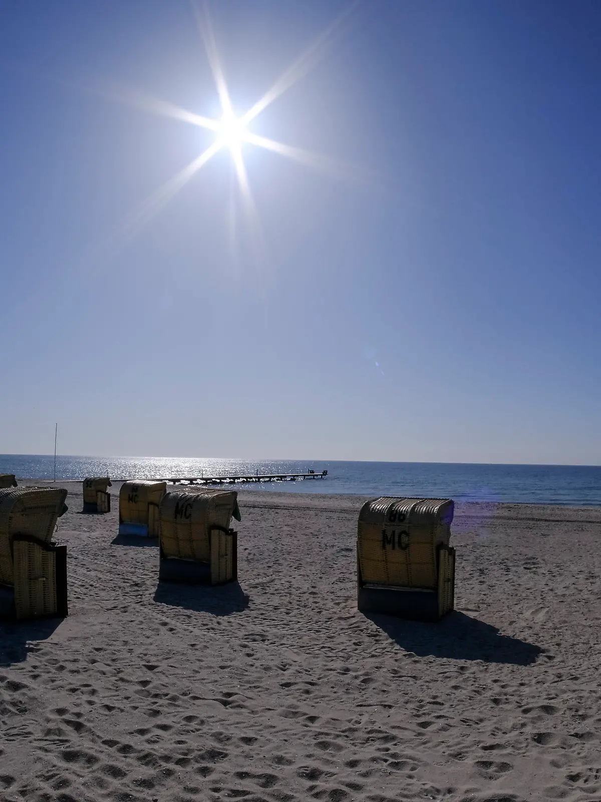 20.04.2021, Schleswig-Holstein, Burgtiefe: Die Sonne scheint bei blauem Himmel auf Strandkörbe am Südstrand auf der Insel Fehmarn. Foto: Frank Molter/dpa +++ dpa-Bildfunk +++