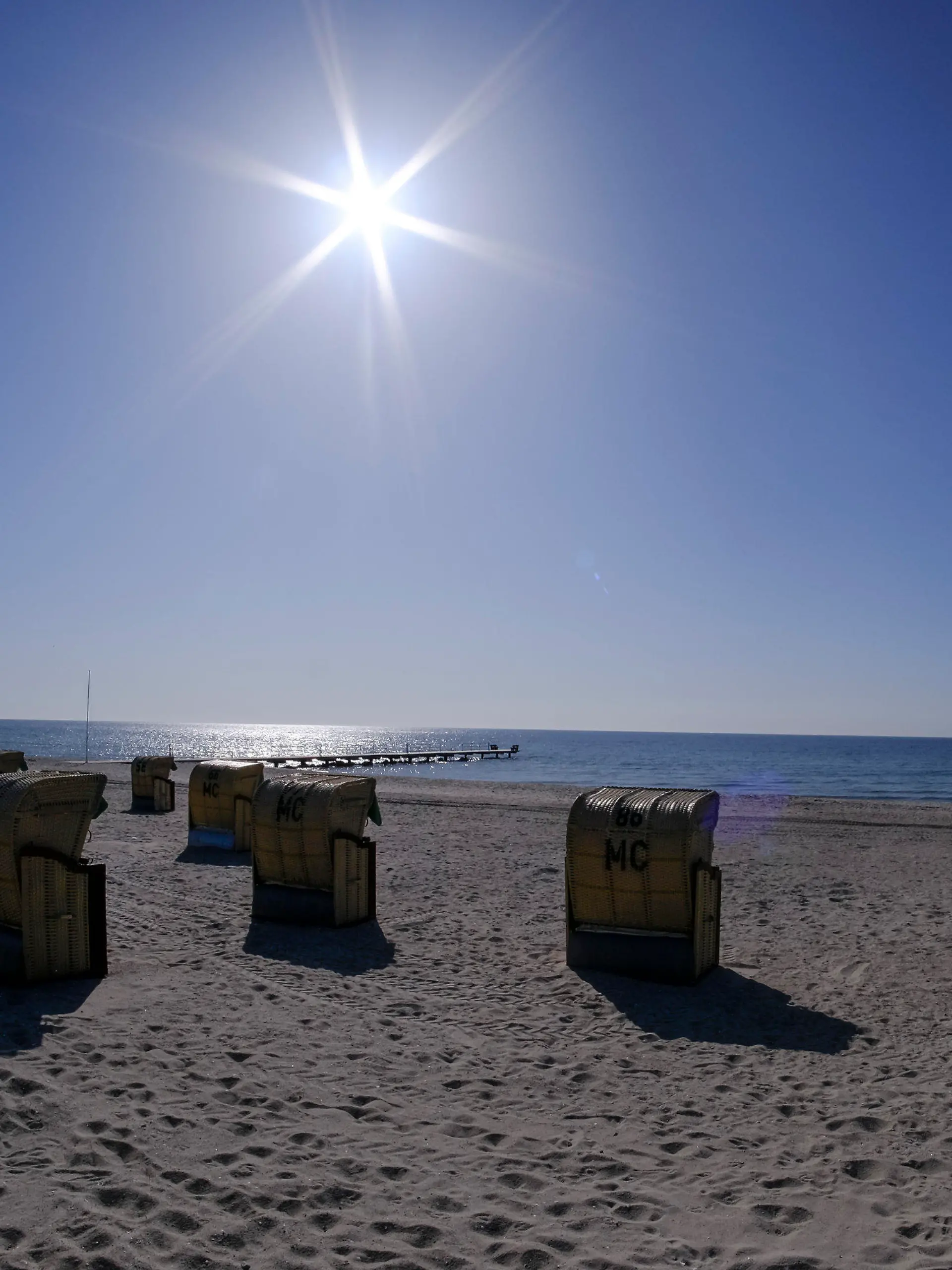 20.04.2021, Schleswig-Holstein, Burgtiefe: Die Sonne scheint bei blauem Himmel auf Strandkörbe am Südstrand auf der Insel Fehmarn. Foto: Frank Molter/dpa +++ dpa-Bildfunk +++
