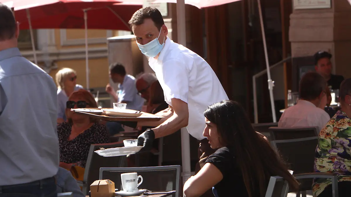  Seit dem heutigen Tage, dem 18.05.2020, dürfen in Bayern unter strengen Auflagen Biergärten und Restaurants wieder Gäste im Außenbereich bewirten, was trotz des warmen und sonnigen Frühlingstag s nicht immer zu vollen Tischen führt: die neuen Regeln zur Hygiene beinhalten eine Desinfektionspflicht von Hände n, Speisekarte n und Tische n sowie die Einhaltung eines Mindesabstands von 1,50 Meter zwischen den Tischen. Das Personal muss zwingend eine Mund-Nasen Schutzmaske und Handschuhe tragen, wie es hier ein Kellner in einem geöffneten Caf in der Innenstadt von Würzburg praktiziert, Bayern, Deutschland. *** As of today, 18 05 2020, beer gardens and restaurants in Bavaria are again allowed to serve guests outdoors under strict conditions, which does not always lead to full tables despite the warm and sunny spring day The new rules on hygie