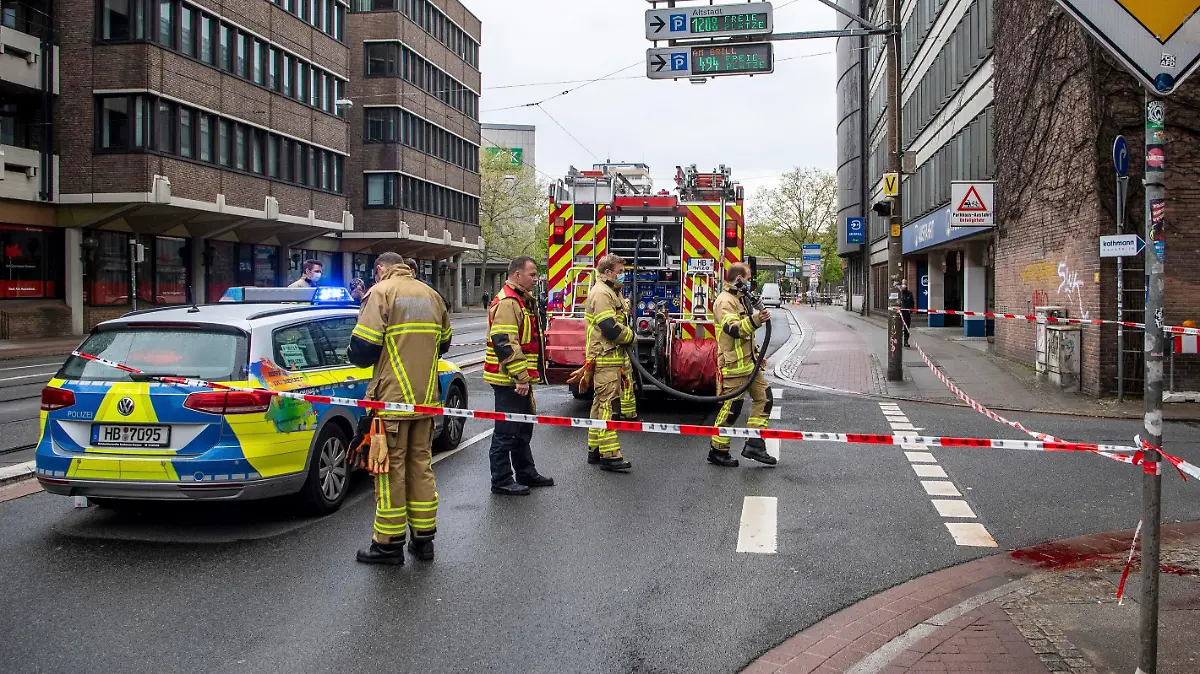 Feuerwehrkräfte stehen in der Nähe des Tatorts einer gewalttätigen Auseinandersetzung.