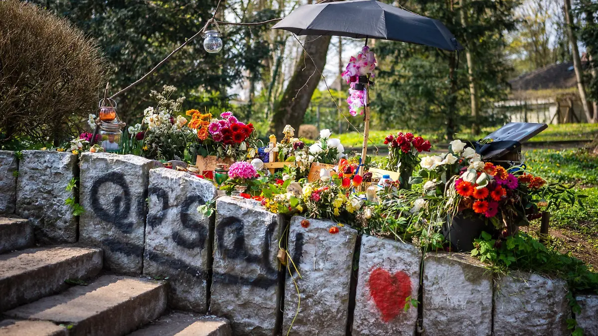 19.04.2021, Niedersachsen, Delmenhorst: Blumen und Kerzen erinnern im Wollepark an einen verstorbenen 19-Jährigen. Bislang ist unklar, warum der Mann nach einem Polizeieinsatz Anfang März starb. Die Anwältin der Familie fordert eine restlose Aufklärung. Die Staatsanwaltschaft ermittelt gegen Polizisten. Foto: Sina Schuldt/dpa +++ dpa-Bildfunk +++