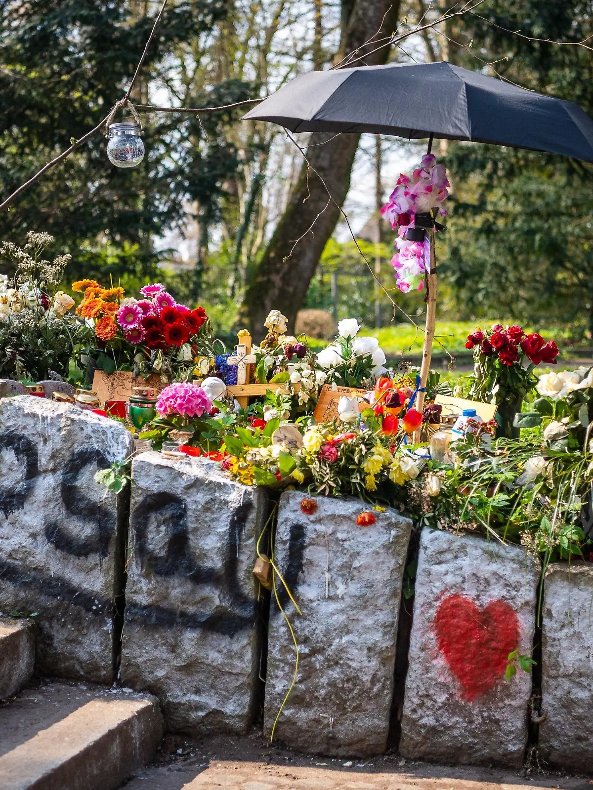 19.04.2021, Niedersachsen, Delmenhorst: Blumen und Kerzen erinnern im Wollepark an einen verstorbenen 19-Jährigen. Bislang ist unklar, warum der Mann nach einem Polizeieinsatz Anfang März starb. Die Anwältin der Familie fordert eine restlose Aufklärung. Die Staatsanwaltschaft ermittelt gegen Polizisten. Foto: Sina Schuldt/dpa +++ dpa-Bildfunk +++