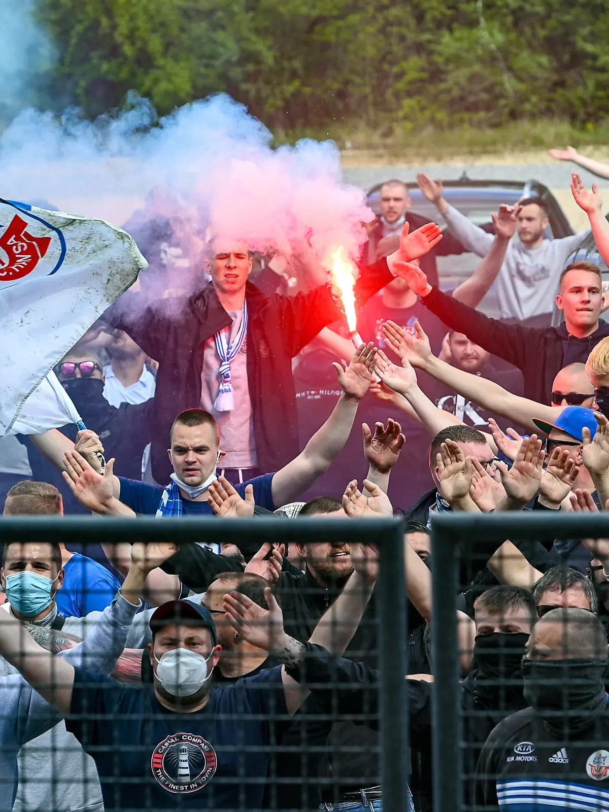  Fans des FC Hansa Rostock brenen nach dem Spiel vor dem Stadion Bengalos und Rauchbomben ab und feiern mit der Mannschaft die sich durch die Lücke auf der Tribüne zeigt, den Auswärtssieg, Bengalo, Bengalos, Feuerwerk, flare, Fans, Publikum, Zuschauer, Stimmung, Atmosphäre, Stadion, 15.05.2021, Unterhaching Deutschland, Fussball, 3. Liga, SpVgg Unterhaching - F.C. Hansa Rostock, DFB/DFL REGULATIONS PROHIBIT ANY USE OF PHOTOGRAPHS AS IMAGE SEQUENCES AND/OR QUASI-VIDEO. *** Fans of FC Hansa Rostock burn bengalos and smoke bombs outside the stadium after the match and celebrate the away victory with the team showing through the gap in the stands, bengalo, bengalos, fireworks, flare, fans, crowd, spectators, atmosphere, stadium, 15 05 2021, Unterhaching Germany , football, 3 Liga, SpVgg Unterhaching F C Hansa Rostock, DFB DFL REGULATES PROHIBIT ANY USE OF PHOTOGRAPHS AS IMAGE SEQUENCES AND OR QUASI VIDEO xslx